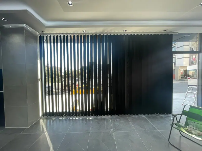 Cam cephe önünde geçirgen bir bölücü oluşturan antrasit keçe mesh perde