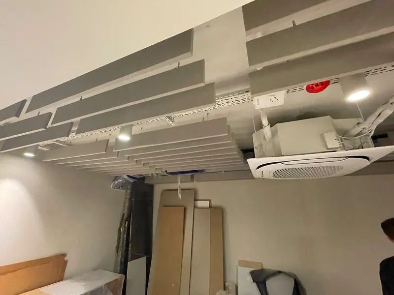 Açık ofis tavanında paralel sıralar halinde kumaş kaplı baffle uygulaması